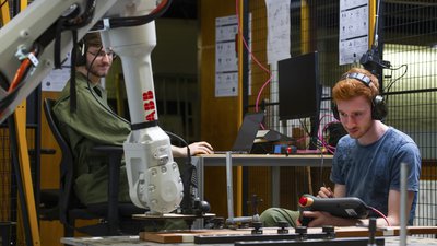 Two students control robot and adapt wood -- klik op de afbeelding om te vergroten