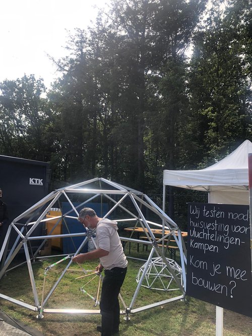Vrijwilliger bouwt aan tent van FlexiDome op Into The Great Wide Open