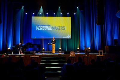 Dagvoorzitter Eveline van Rijswijk op het podium van het SIA-congres 2022 -- klik op de afbeelding om te vergroten
