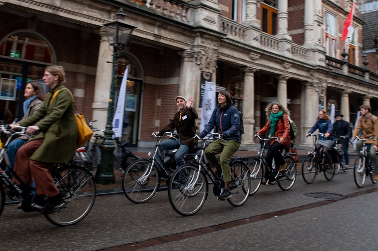 Deelnemers aan het SIA-congres zijn in optocht op de fiets onderweg naar een excursie.