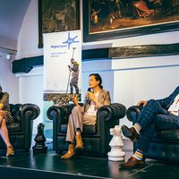 3 mensen op een stoel in gesprek met elkaar -- klik op de afbeelding om te vergroten
