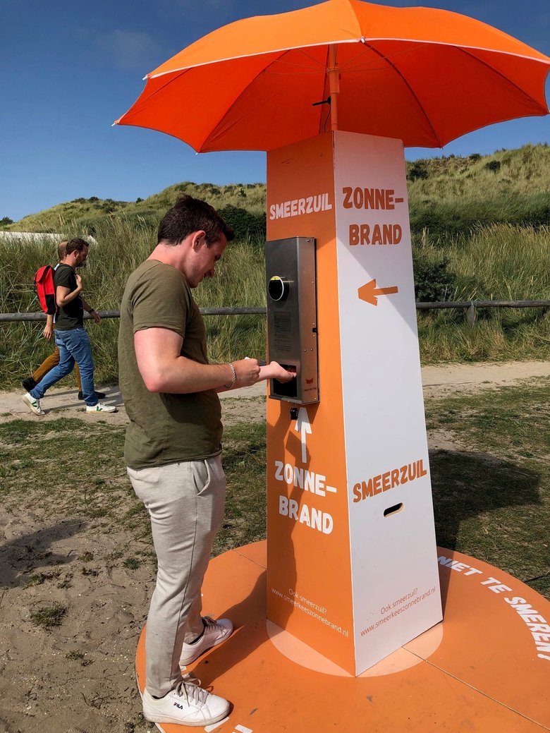 Campinggast gebruikt de zonnebranddispenser