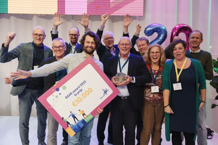 Groep mensen juicht met cheque in de hand