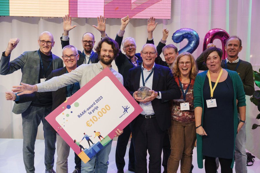 Groep mensen juicht met cheque in de hand