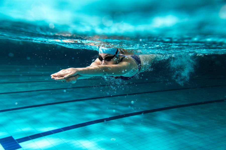Een wedstrijdzwemmer onderwater in een zwembad