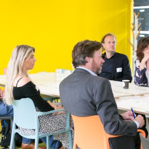Mensen aan tafels tijdens SPRONG kick-off 2022